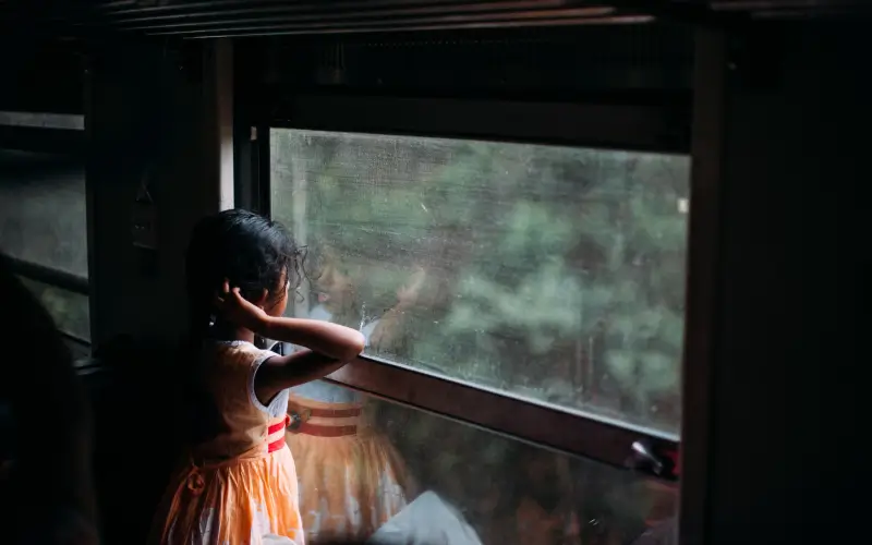little-girl-loooking-out-a-train-shutter-in-sri-lanka